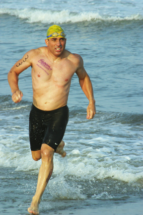 Palisadian Drew Daniele comes ashore at the T. John Carey Masters Ocean Swim in Ocean City, New Jersey in July, with the Swim With Mike tattoo across his chest.